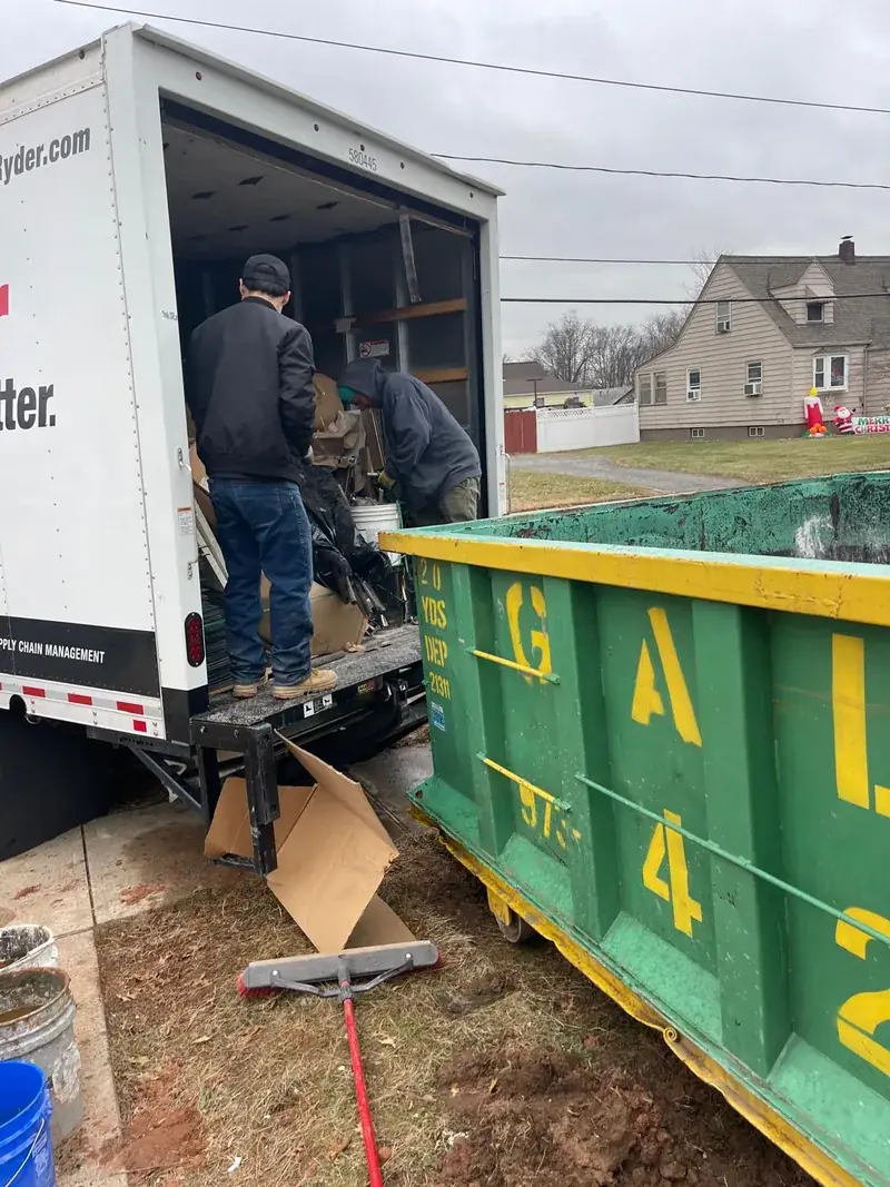 Alpha Project crew unloading a truck into a dumpster during a junk removal job in New Jersey