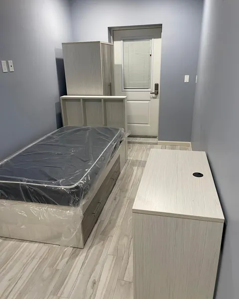 Bed, wardrobe and desk assembled in a residence room