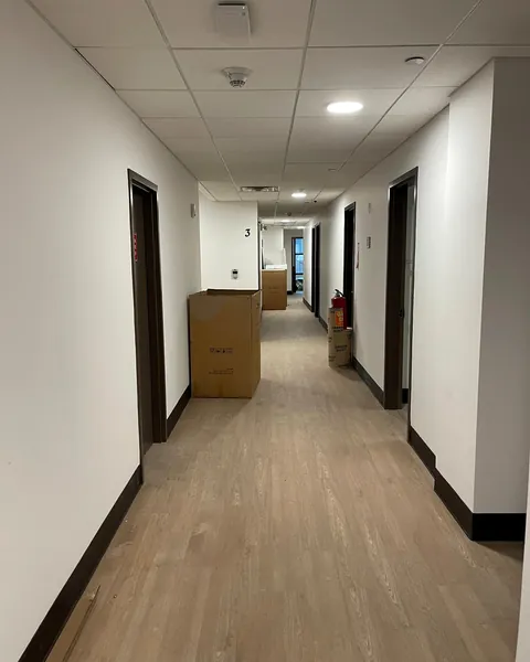 Boxed furniture staged along an office corridor