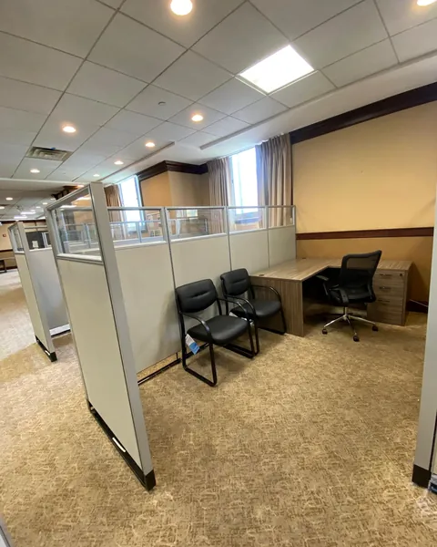 Cubicle workstation with L-desk and guest chairs